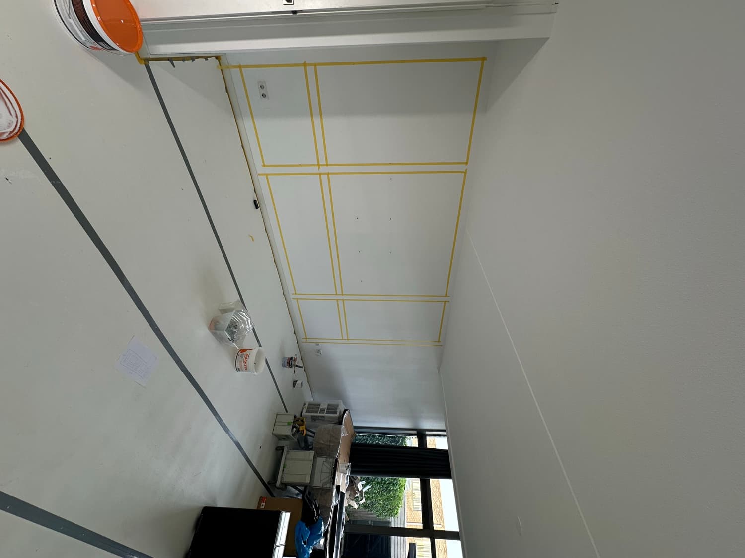 Wand waarop de panelen met tape zijn uitgezet