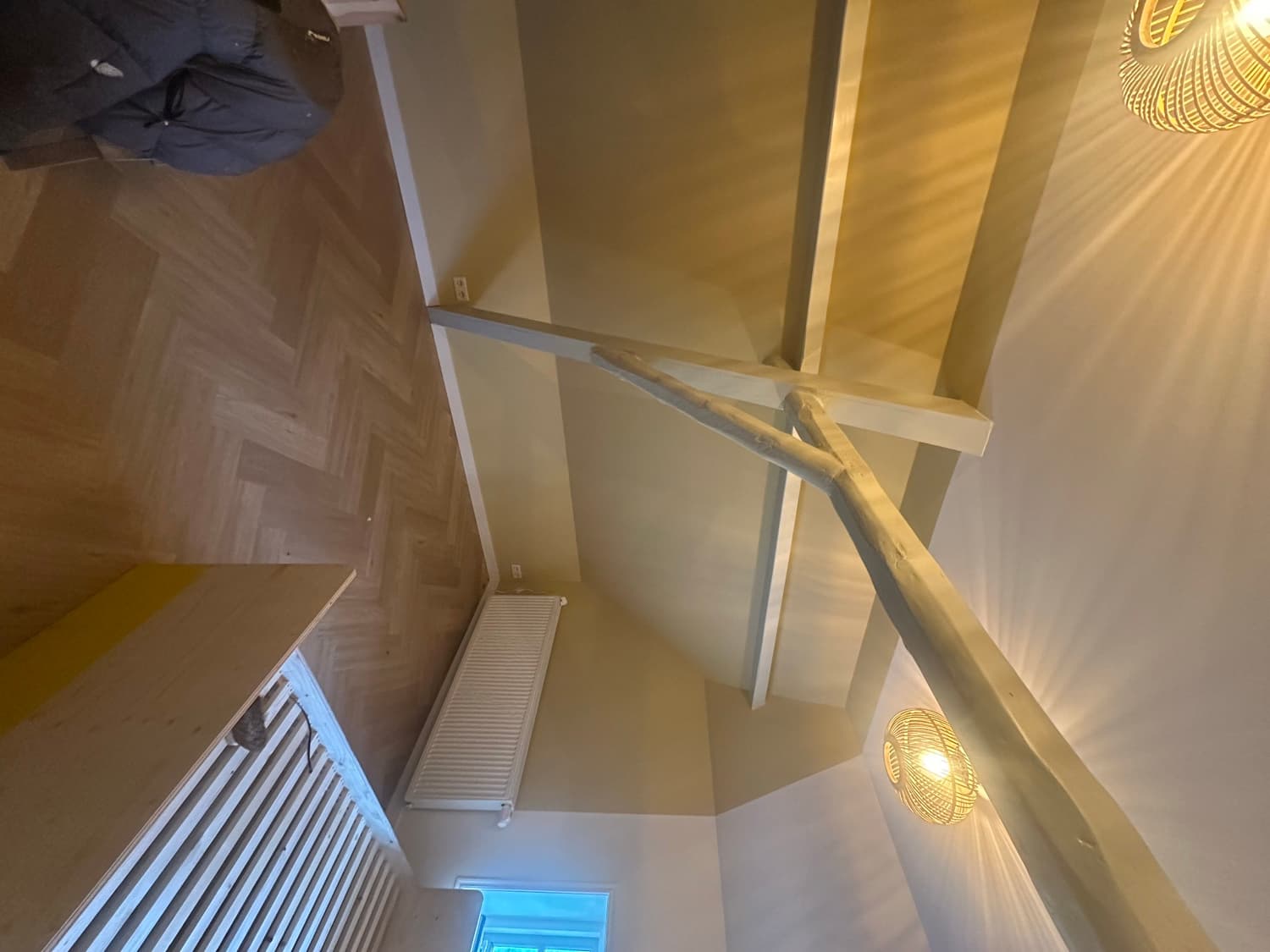 Zolderkamer met kale balken en beige wanden, voor het schilderen