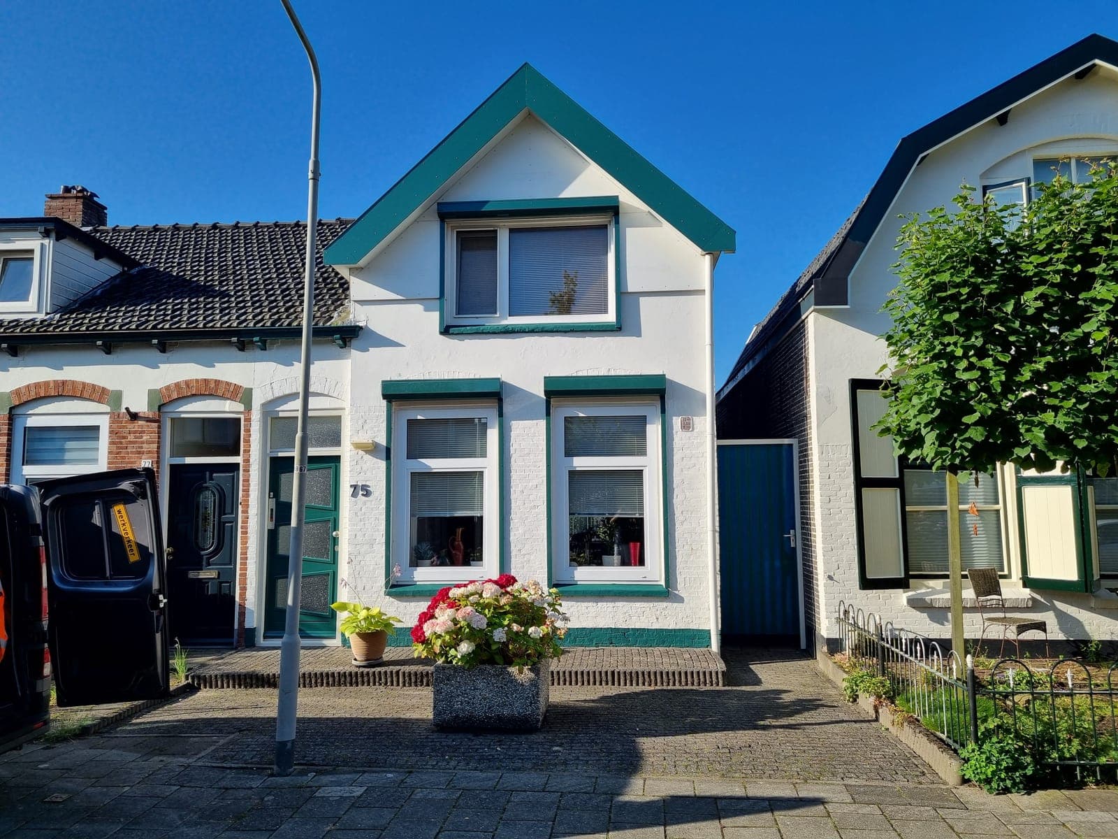 Wit geschilderde gevel met groen gelakte kozijnen
