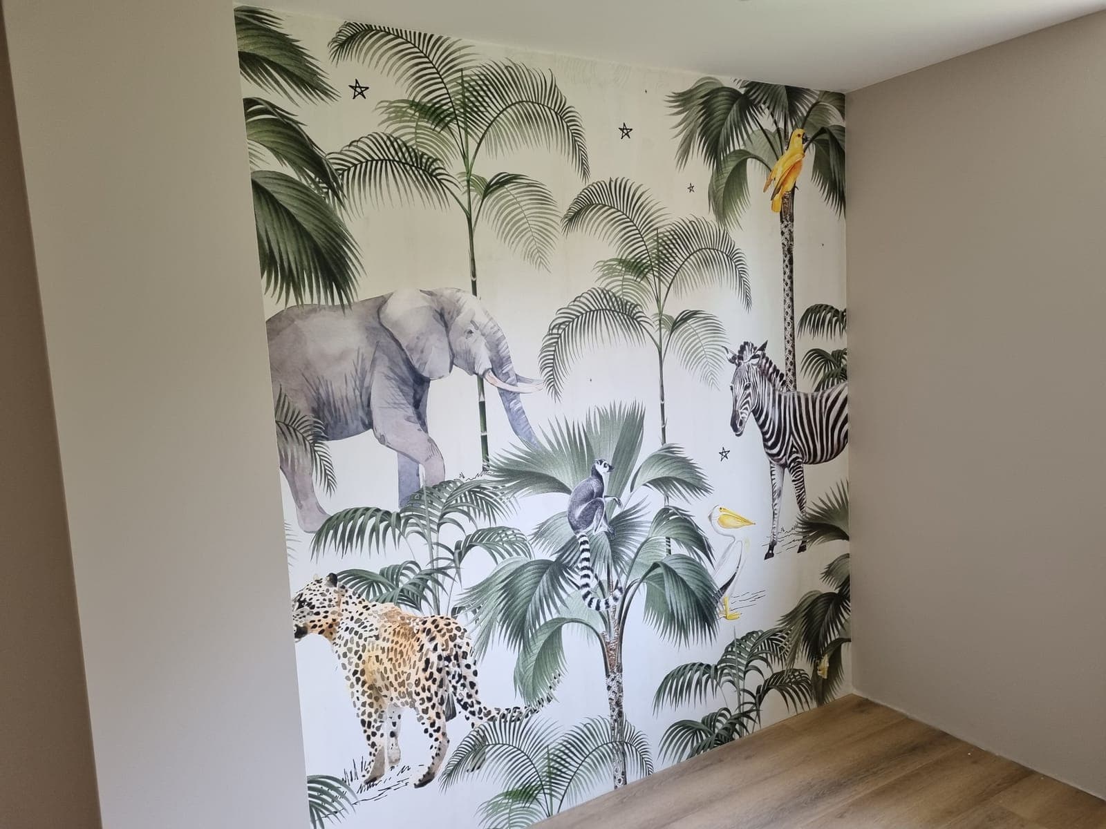 Children's room with jungle wallpaper and an evenly painted wall